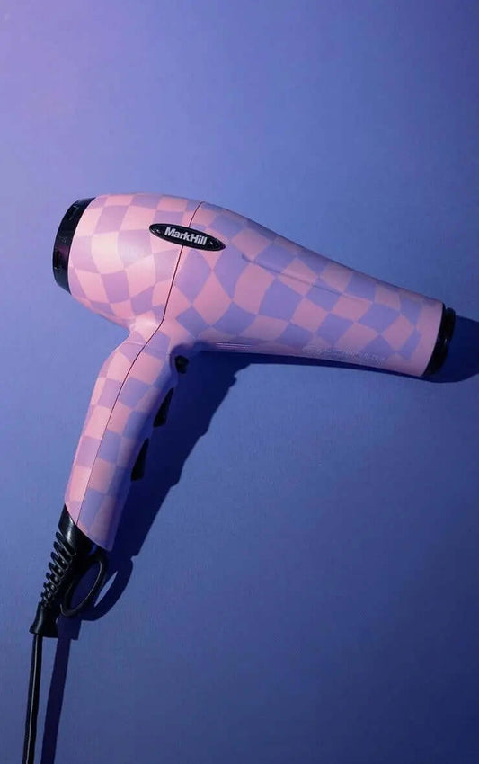 Mark Hill Lavender Haze Hairdryer in pink checkered design against a purple background, showcasing stylish fast drying technology.