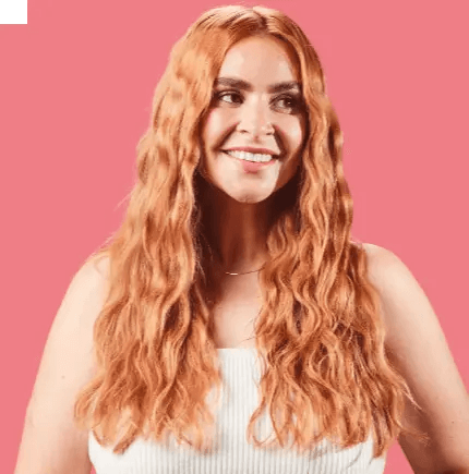 Model showcasing defined beachy waves styled with Mark Hill Pretty In Pink Mermaid Waver 21mm against a pink background.