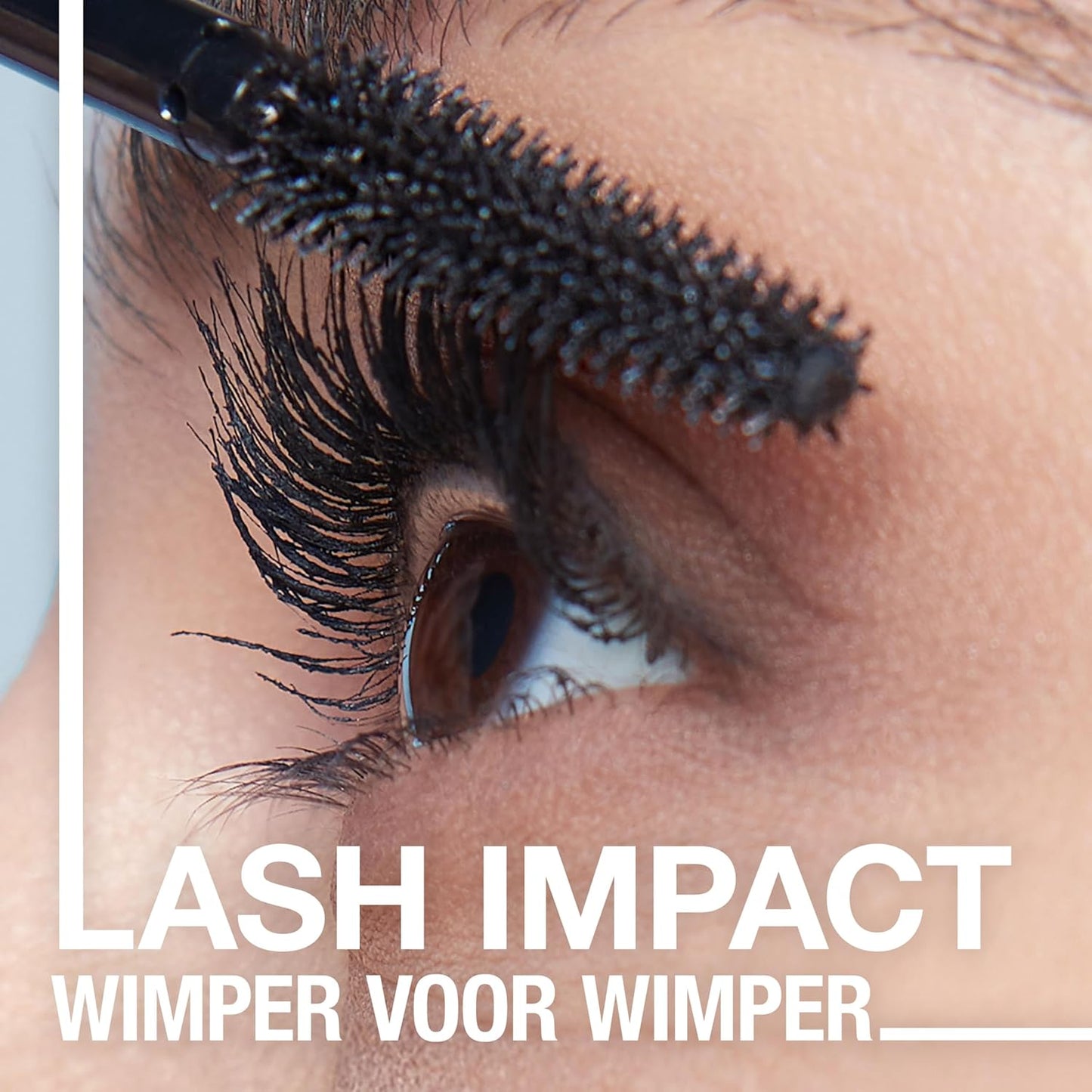 Eyelash curler being used on an eye with text Maybelline 'LASH IMPACT WIMPER VOOR WIMPER' below.