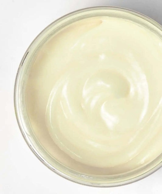 Close-up of Mielle Organics Babassu Oil & Mint Deep Conditioner in a jar, showcasing its creamy texture.