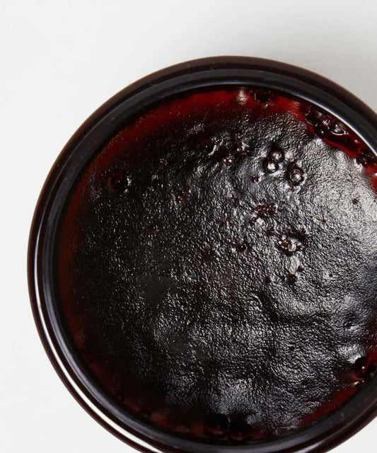 MIELLE ORGANICS Rosemary Mint Strengthening Edge Gel in a black jar, showcasing a glossy, rich texture.