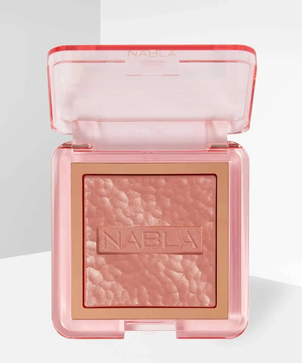 NABLA Skin Glazing highlighter in a pink compact, showcasing a textured baked powder for luminous complexion.