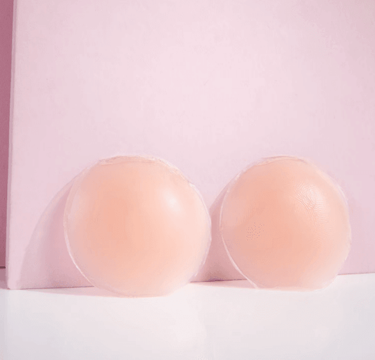 Brushworks silicone nipple covers shown on a pink background, smooth and discreet for braless wear.