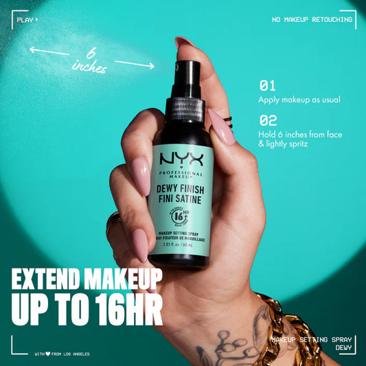 Hand holding a NYX makeup setting spray against a teal background