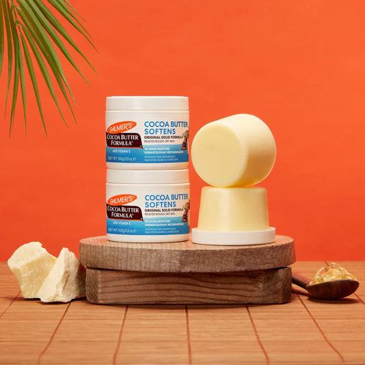 Palmer's Cocoa Butter Formula products on a wooden stand with an orange background