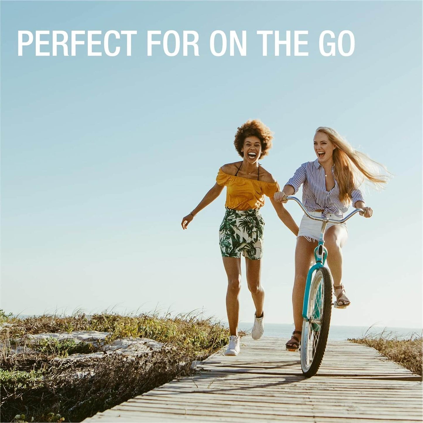 Two friends joyfully enjoying a bike ride by the beach, depicting an active lifestyle and outdoor fun.