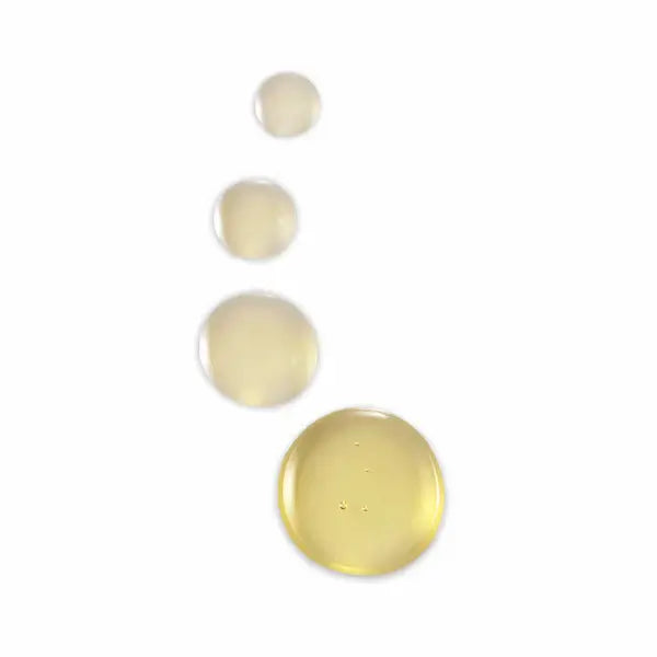 Four droplets of PHILIP B Scalp Booster pre-wash treatment showcasing its lightweight, invigorating oil texture.