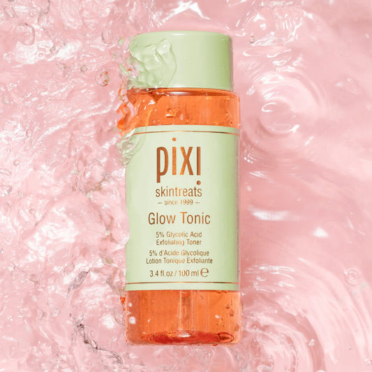 PIXI Glow Tonic bottle on a pink water background