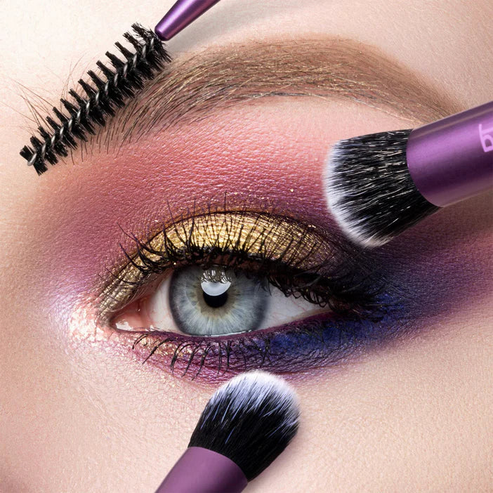 Close-up of a person applying makeup with a purple brush on their eye.