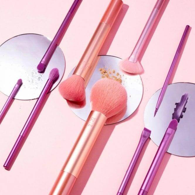 Real Techniques Insta Artist 9 Piece Makeup Brush Set displayed on a pink background, featuring various brushes and tools.