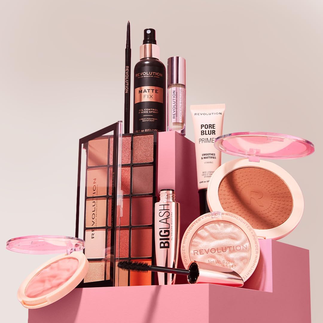 Collection of Revolution makeup products on a pink platform with a light gray background