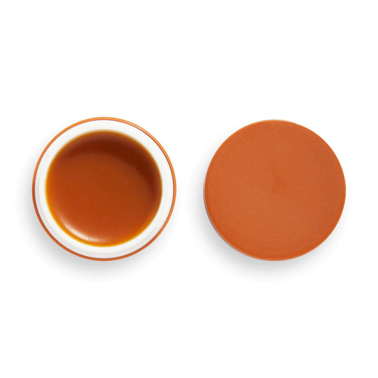 Revolution Skincare Chocolate Caramel Lip Sleeping Mask in a round jar, highlighting its rich, hydrating texture.