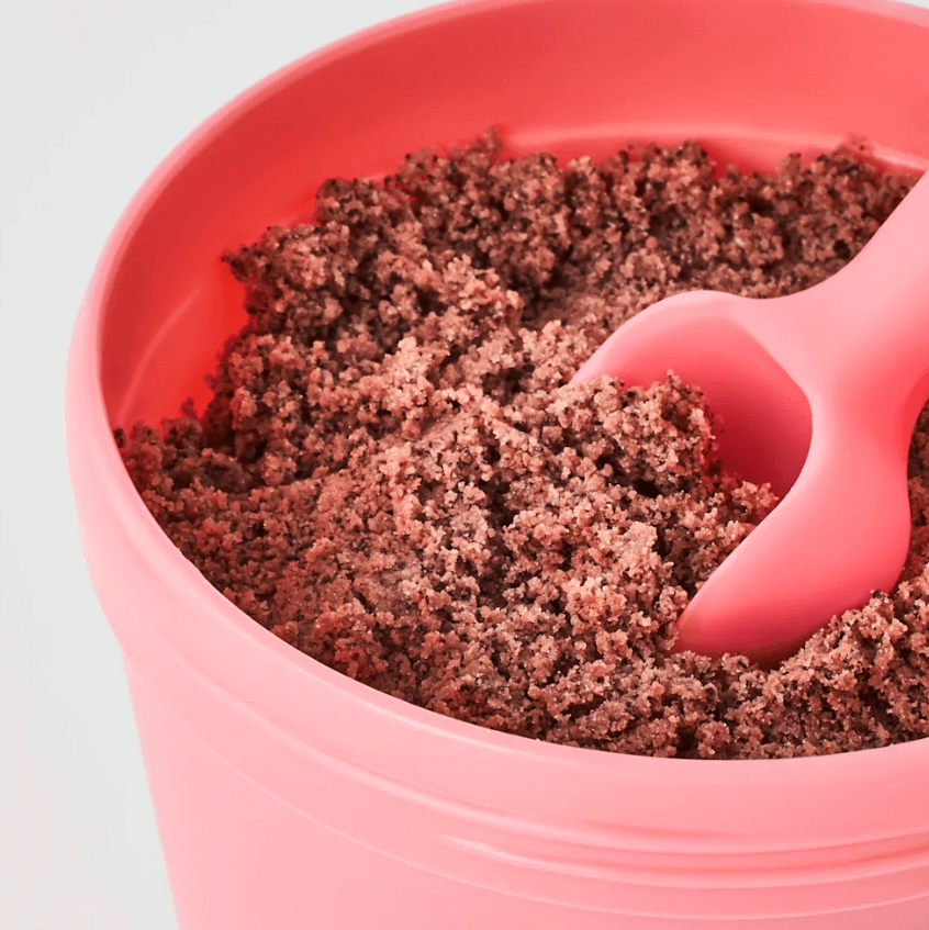 Close-up of Sand & Sky Australian Pink Clay Smoothing Body Sand in a pink container with a scoop.