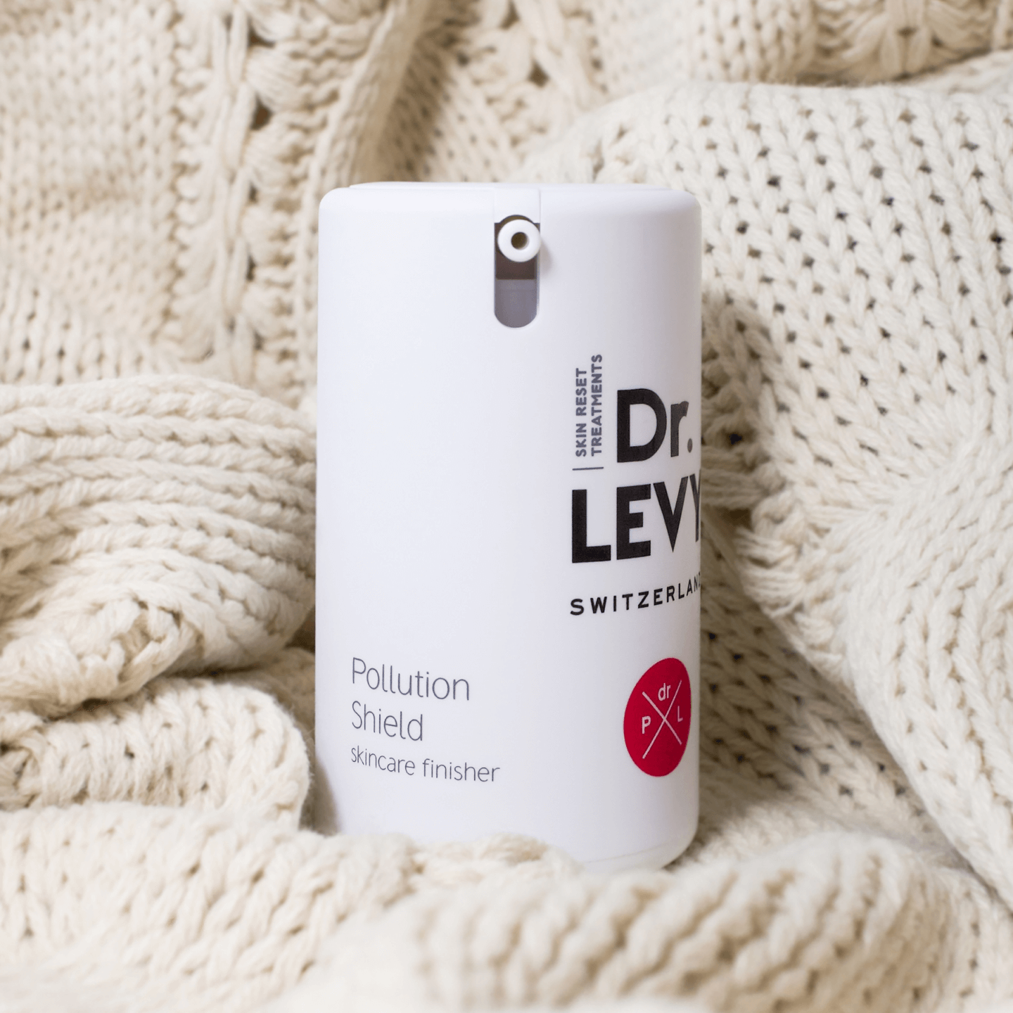 Dr. LEVY Switzerland Pollution Shield 5PF skincare finisher on a soft knitted background.