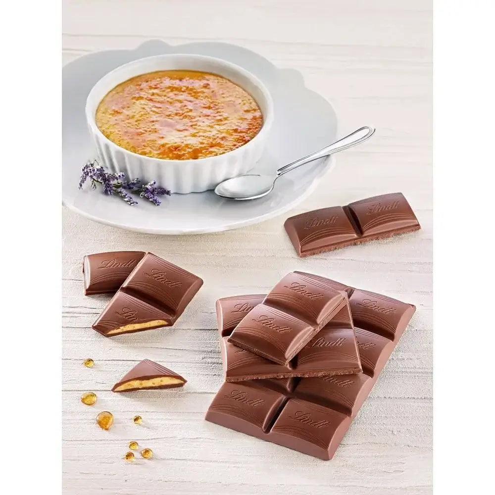 Lindt Chocolate pieces with a bowl of creme bréleé on a white surface