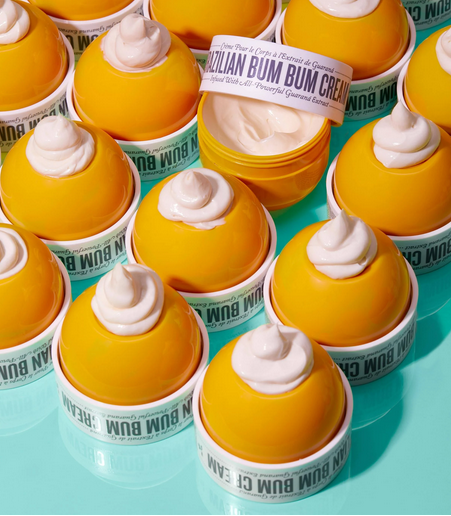 Multiple containers of Sol de JaneiroBrazilian Bum Bum Cream on a blue background