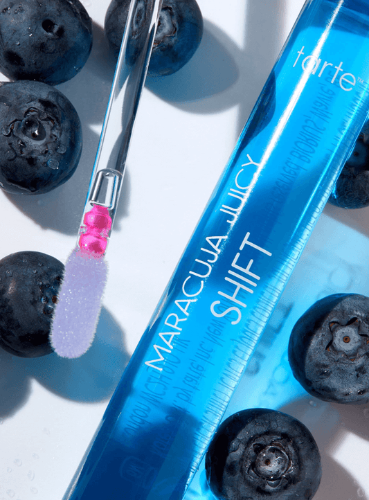 Tarte Maracuja Juicy Lip & Cheek Shift in Blueberry with applicator and blueberries, showcasing vibrant color transformation.