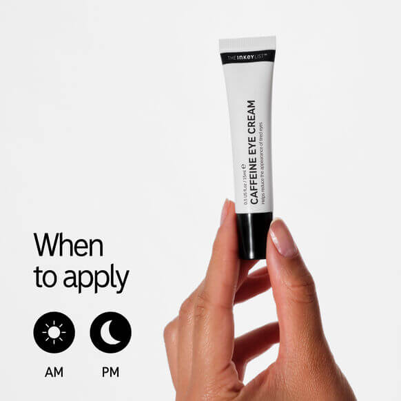 Tube of The INKEY List Caffeine Eye Cream held by a hand with application timing icons on a white background.