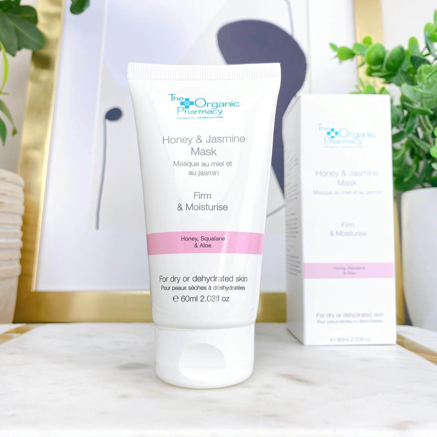 The Organic Pharmacy Honey & Jasmine Mask 60ml in a stylish setting, perfect for moisturizing and firming dry skin.