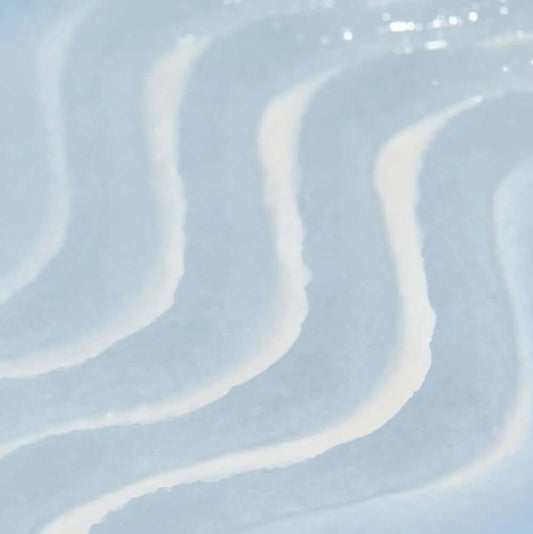 Wavy lines of TREE HUT Sugar Scrub Exotic Bloom creating a smooth texture, representing soothing skin care benefits.