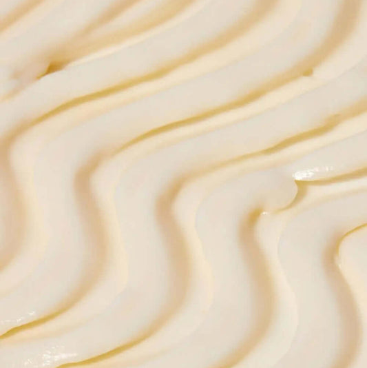Close-up of creamy, Tree Hut Whipped Body Butter Tropic Glow whipped body butter with smooth, textured swirls, perfect for hydration and nourishment.