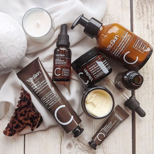 VitaSkin skincare products on a wooden surface with a candle and soap.