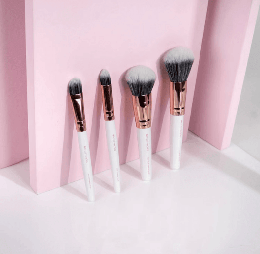 Brushworks Travel Brush Set in white and gold, featuring four essential makeup brushes against a pink background.