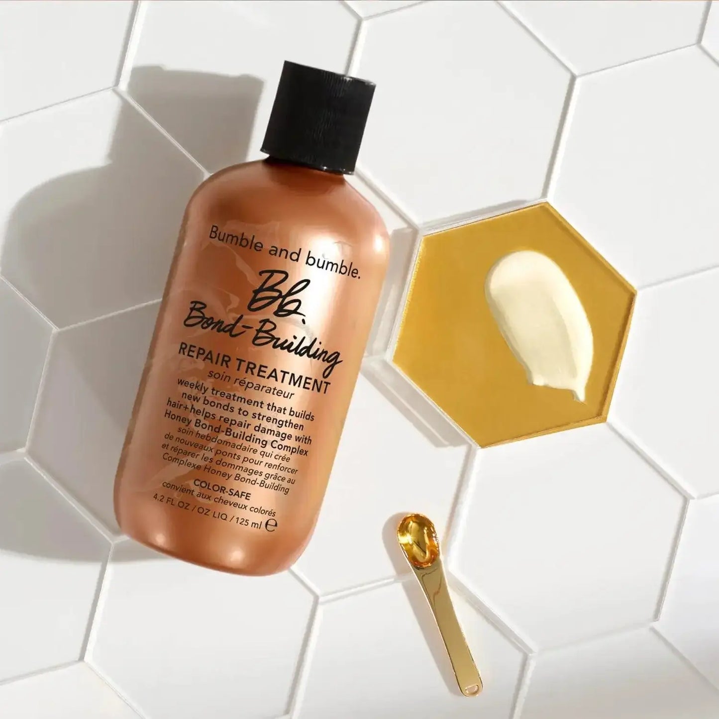 Bumble and bumble Bond-Building Repair Treatment 125ml with a hexagon dish of product and applicator on a white tiled surface.
