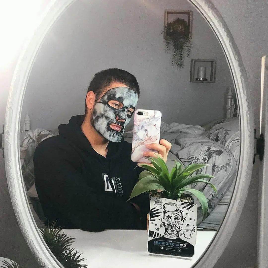 Person using BARBER PRO Foaming Cleansing Mask with Activated Charcoal, showcasing a deep cleanse effect in a mirror.