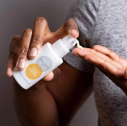 Person applying Balance Me Vitamin C Repair Serum 30ml to hand for bright, youthful skin.