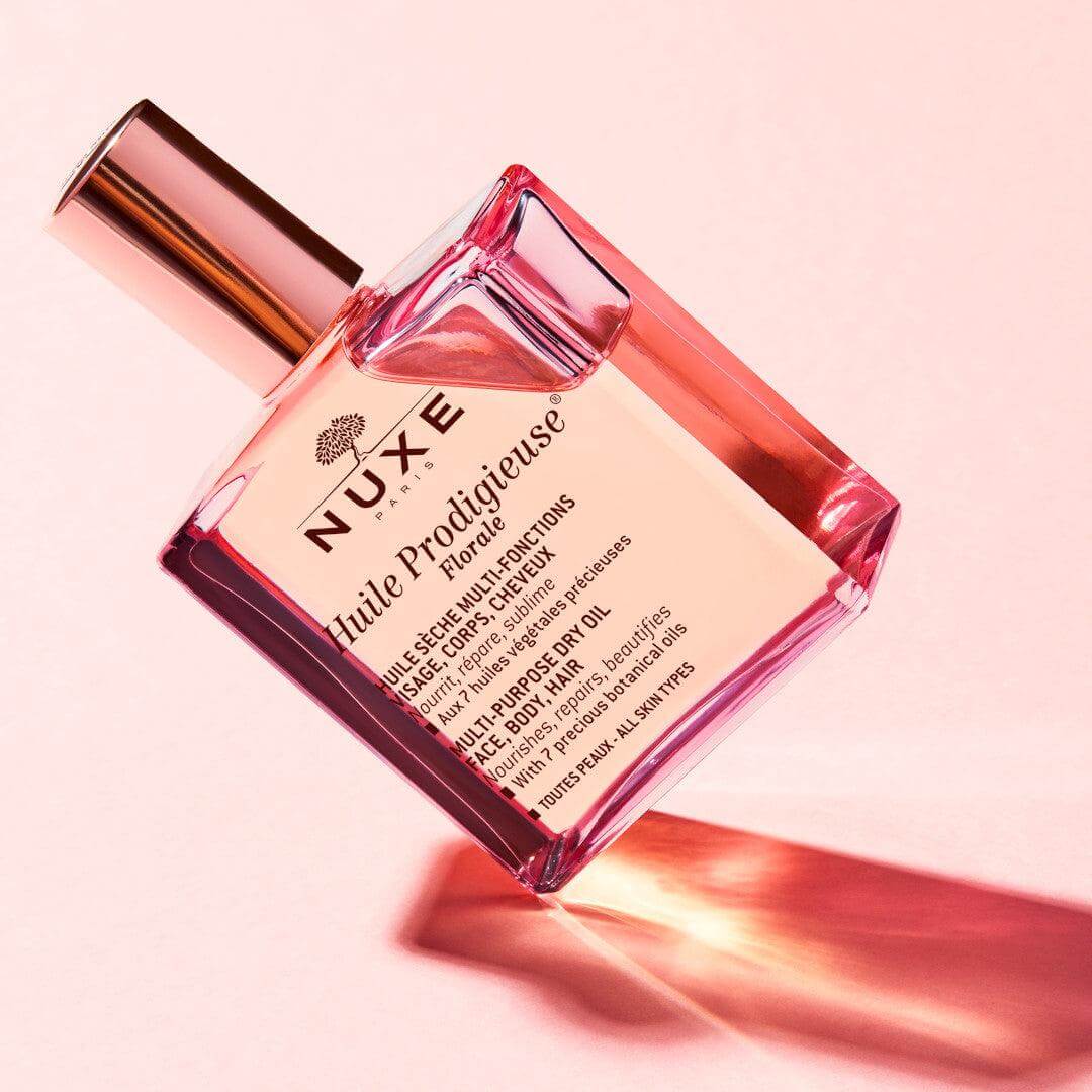 NUXE Huile Prodigieuse Florale 30ml bottle on pink background, featuring multi-purpose dry oil for body, face, and hair.