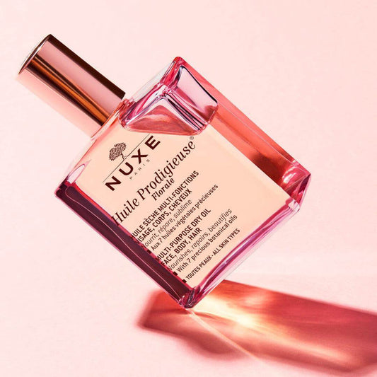 NUXE Huile Prodigieuse Florale 30ml bottle on pink background, featuring multi-purpose dry oil for body, face, and hair.