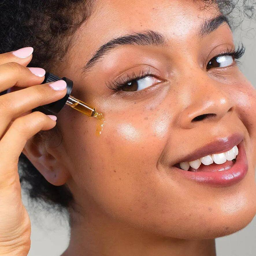 Woman applying Odacité Wild Carrot Serum Concentrate for a fresh, glowing complexion.