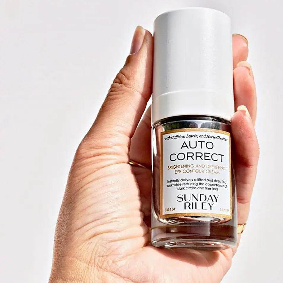 Sunday Riley Autocorrect Eye Contour Cream in hand, 15ml, brightening and depuffing formula.