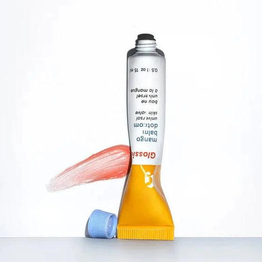 Glossier Balm Dotcom in Mango, a hydrating lip balm tube with sheer tint and antioxidants for moisturized lips.