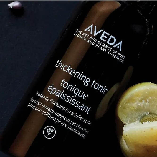 Aveda Hair Thickening Tonic bottle with lemon, enhances hair volume and thickness with natural ingredients.