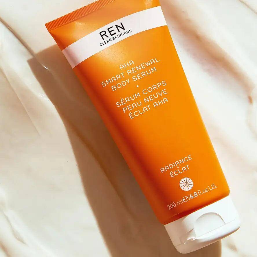 Ren Clean Skincare AHA Smart Renewal Body Serum 200ml in bright orange tube on white background.
