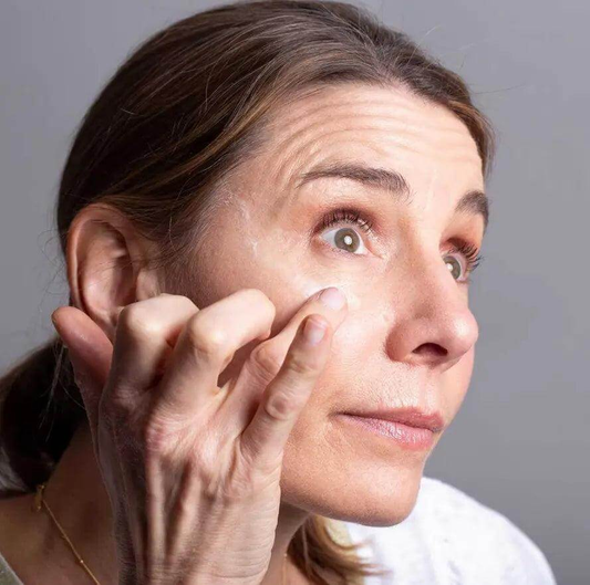 Woman applying Balance Me Wonder Eye Cream to reduce dark circles and puffiness.