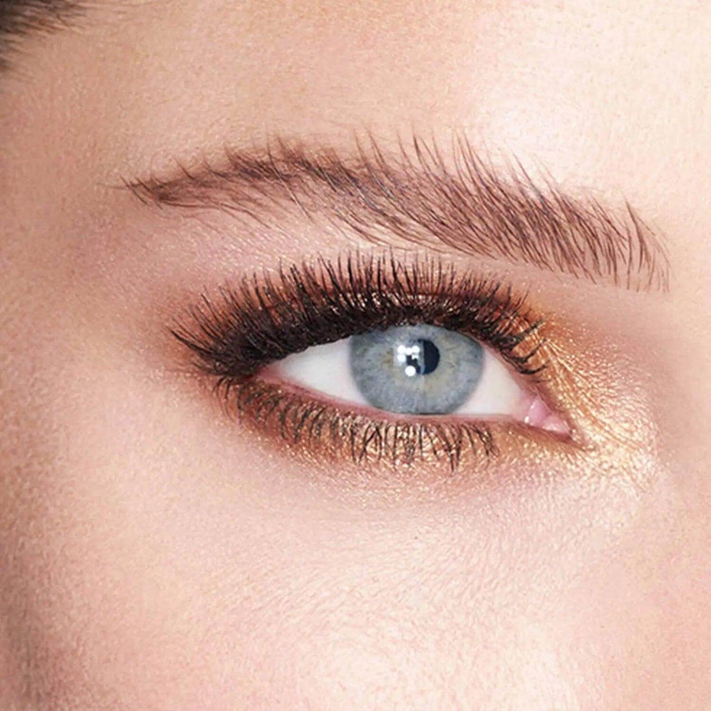 Close-up of an eye showcasing Charlotte Tilbury Eyes To Mesmerise in Amber Gold, highlighting a metallic finish.