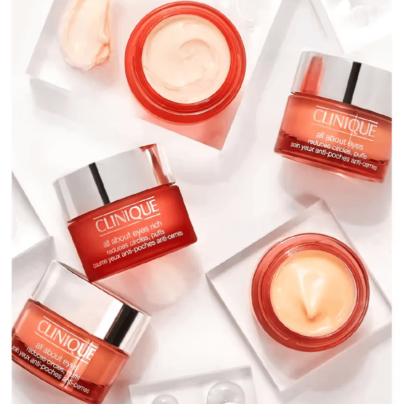 CLINIQUE All About Eyes eye cream jars on a white surface, designed to reduce puffiness and dark circles.