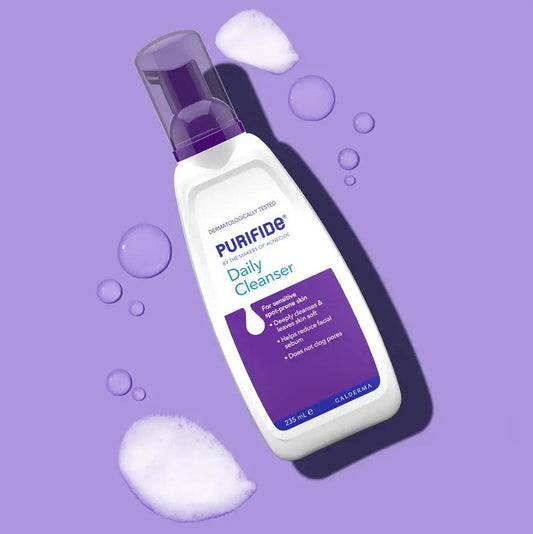 Purifide by Acnecide Daily Cleanser 235ml bottle with bubbles on a purple background, designed for blemish-prone skin.