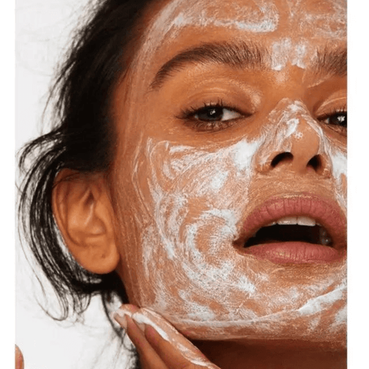 Model applying VERSED Keep The Peace Blemish-Calming Cream Cleanser to her face for clearer skin.