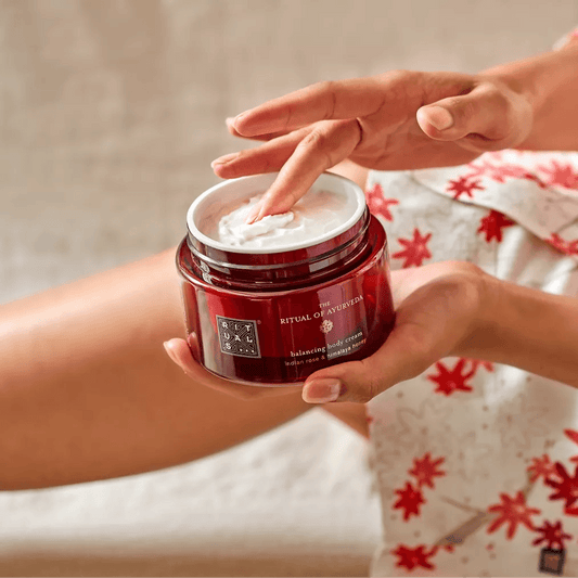 Hand applying RITUALS The Ritual of Ayurveda Body Cream 220ml for nourishing skin with sweet almond oil and Indian rose scent.