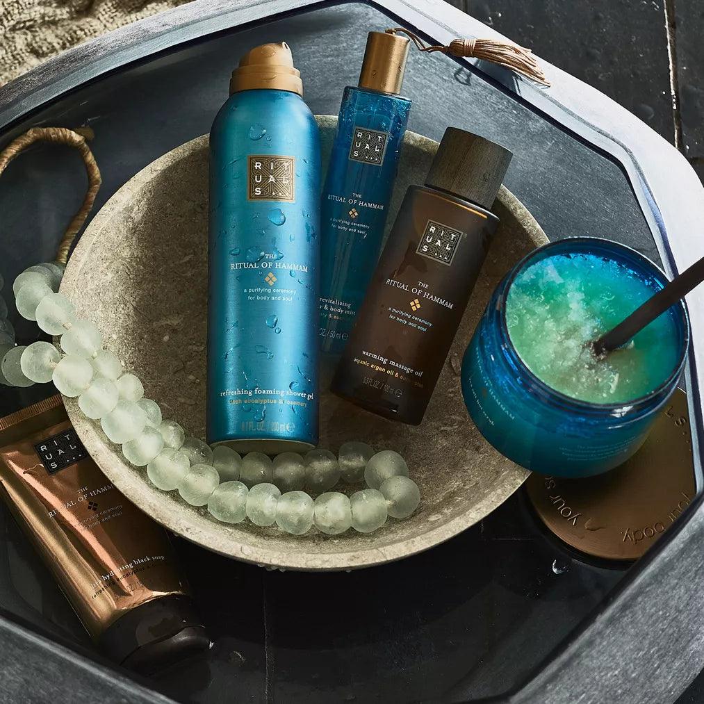 RITUALS The Ritual of Hammam skincare products in a bowl, including exfoliating glove and body care items.
