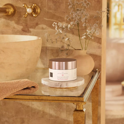 Cosmetic jar on a marble tray with a decorative vase and flowers in a bathroom setting.