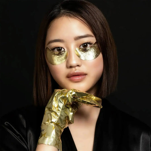 Model wearing STARSKIN Gold Eye Mask with gold foil patches for under-eye rejuvenation and skincare.