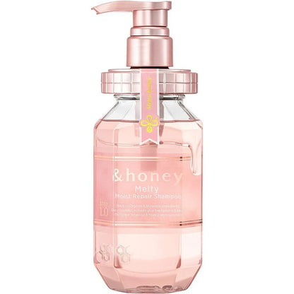 Pink bottle with pump dispenser labeled '& honey' on a white background