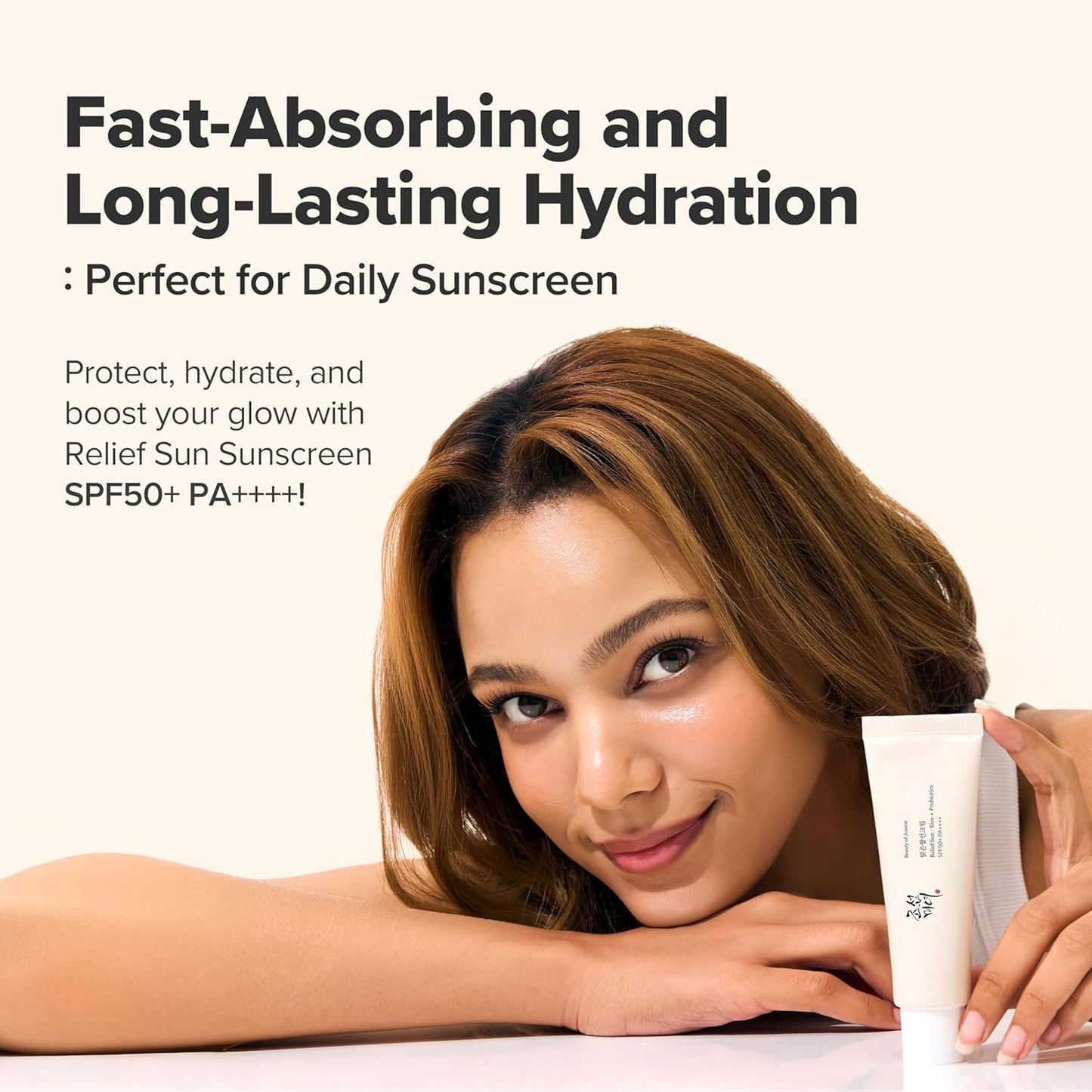 Woman holding a tube of sunscreen with text about fast-absorbing and long-lasting hydration.