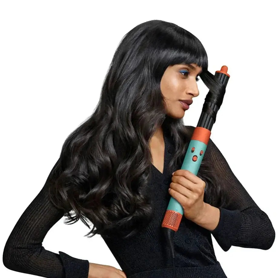 Model holding the Dyson Airwrap I.D. Patina & Topaz styling tool, showcasing waves in long dark hair.