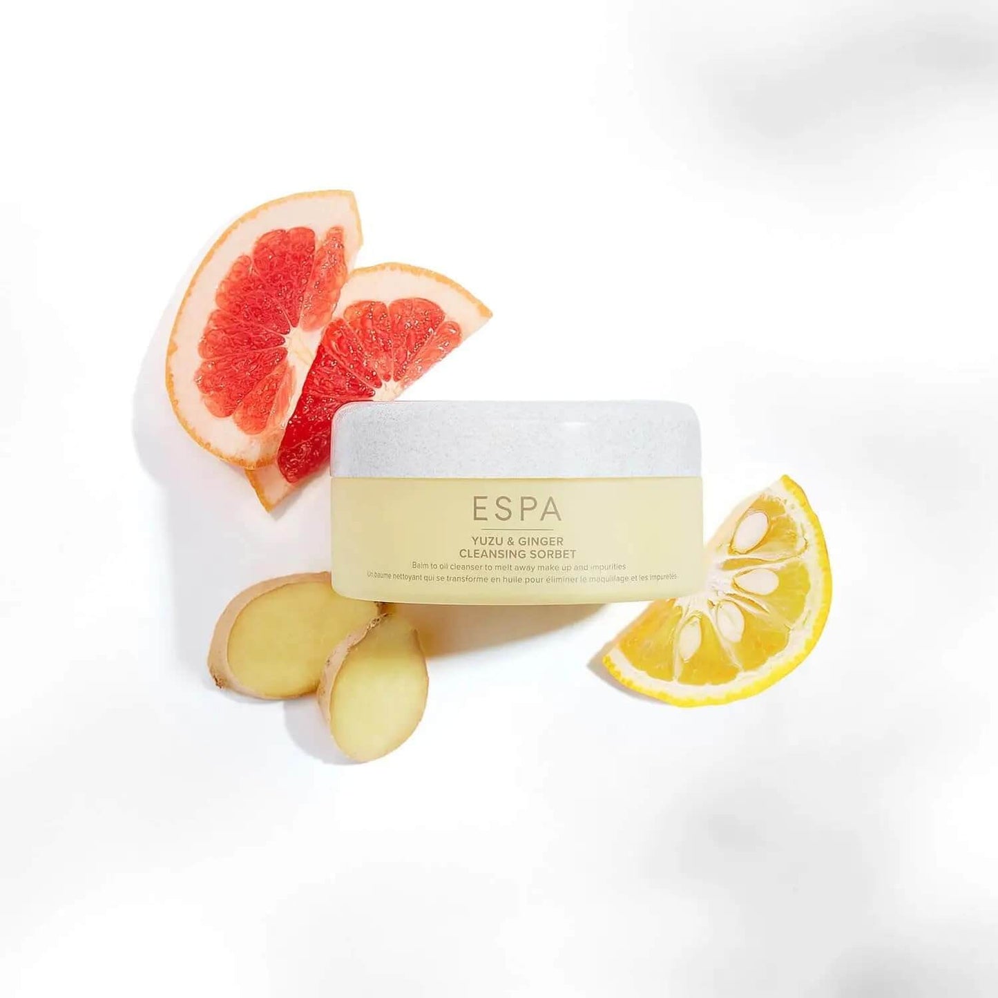 Espa product with grapefruit, ginger, and lemon on a white background